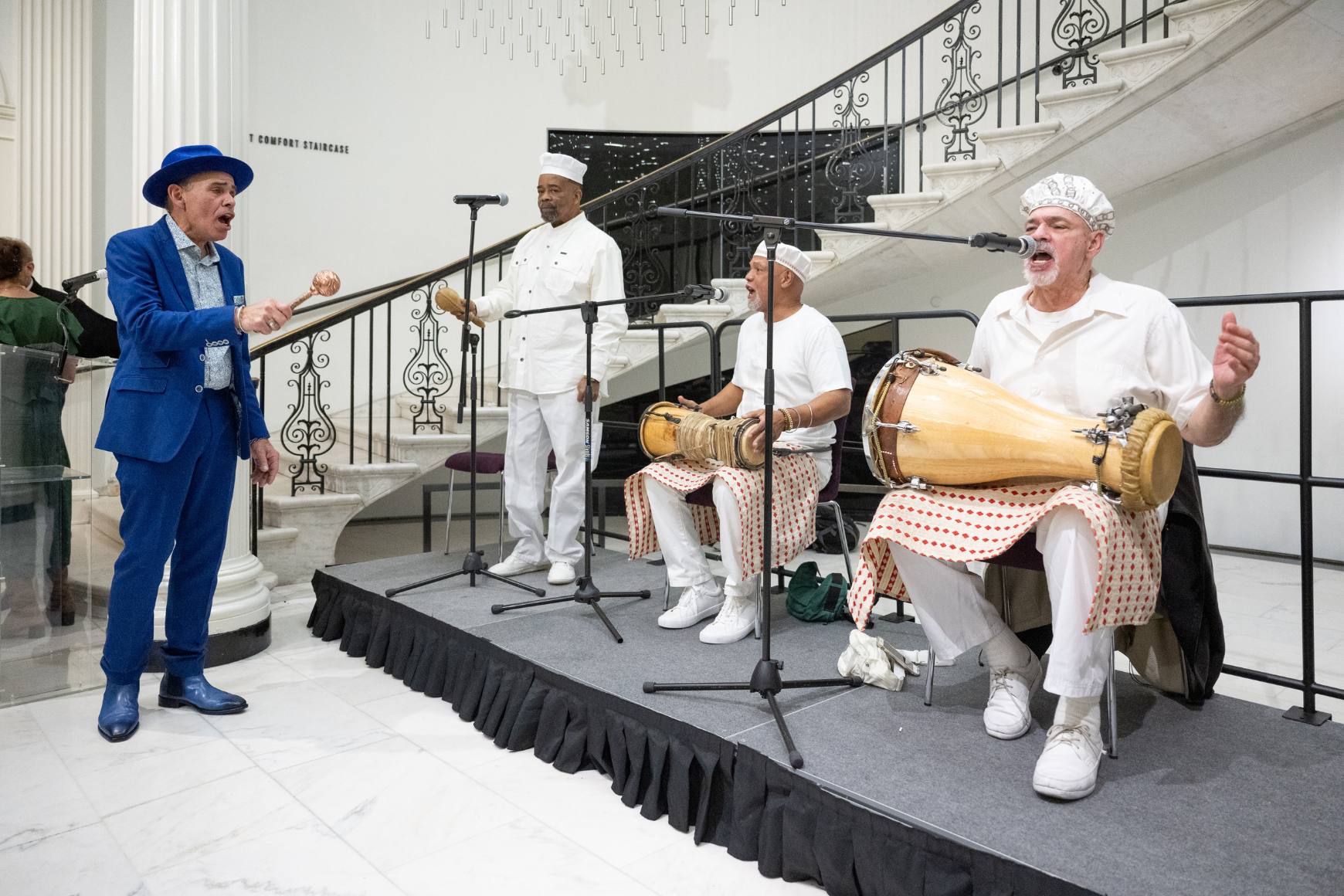 Manny Vega performs with a band of musicians.